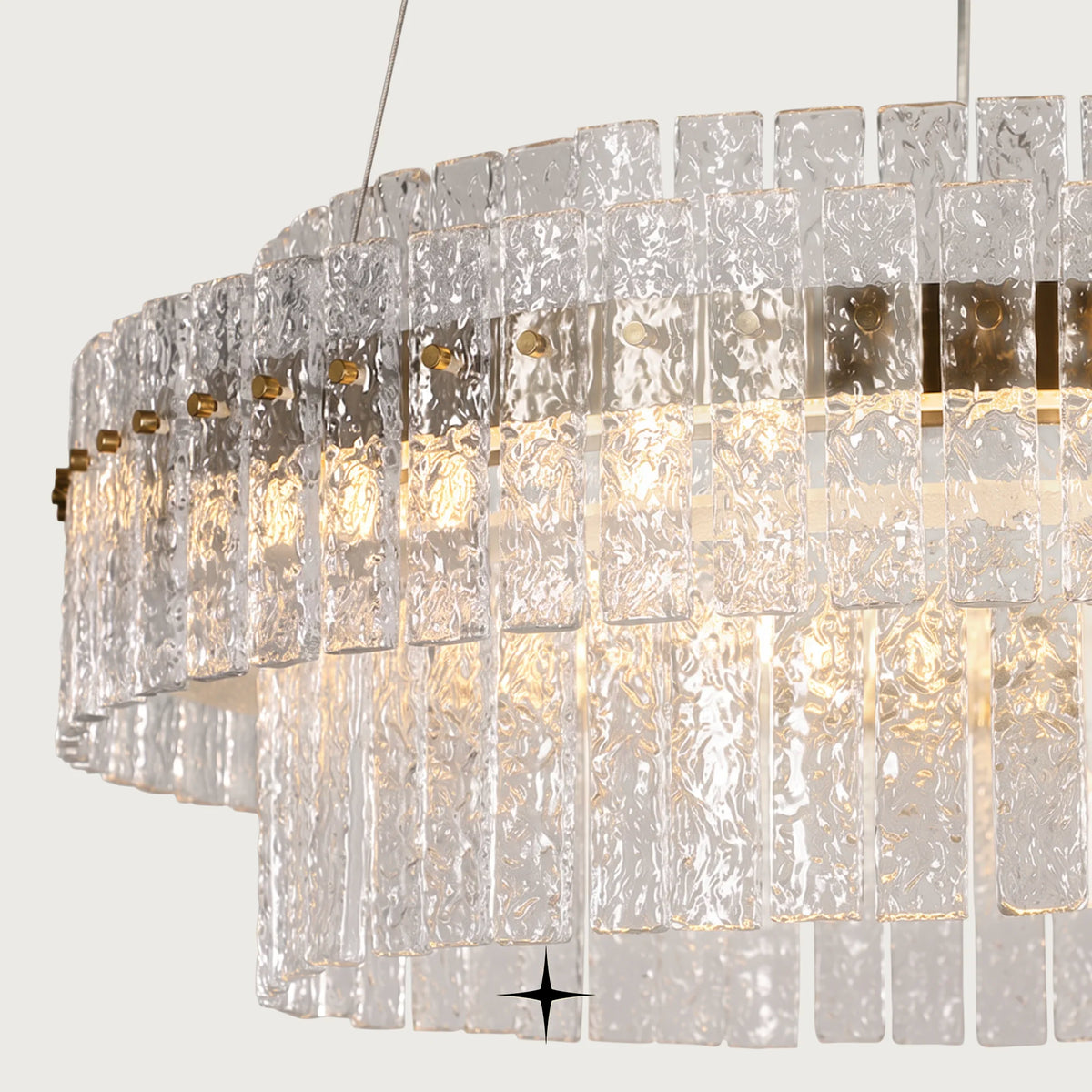 Close-up detail of textured rock-crystal glass diffusers and gold frame on Chime chandelier