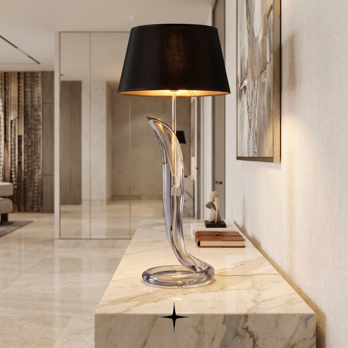 A modern table lamp with a black drum shade and a sculptural, flowing clear glass base, placed on a white marble console table in a luxurious hallway.