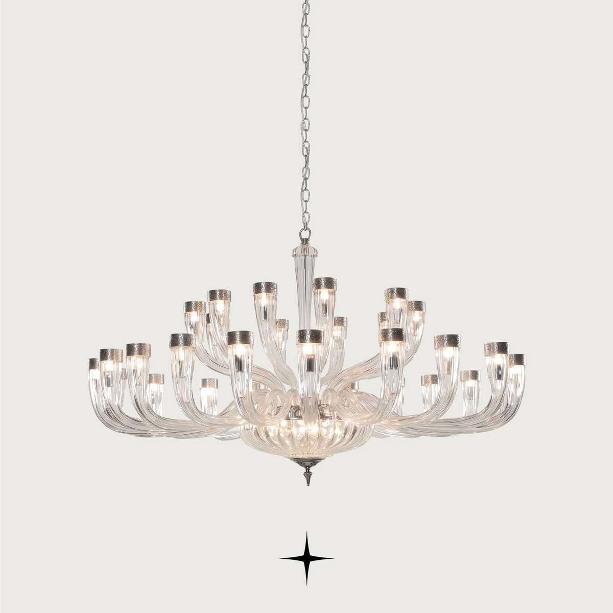 Grand Bianca Chandelier featuring chic elongated crystal arms available in three sizes and gold or silver finishes.