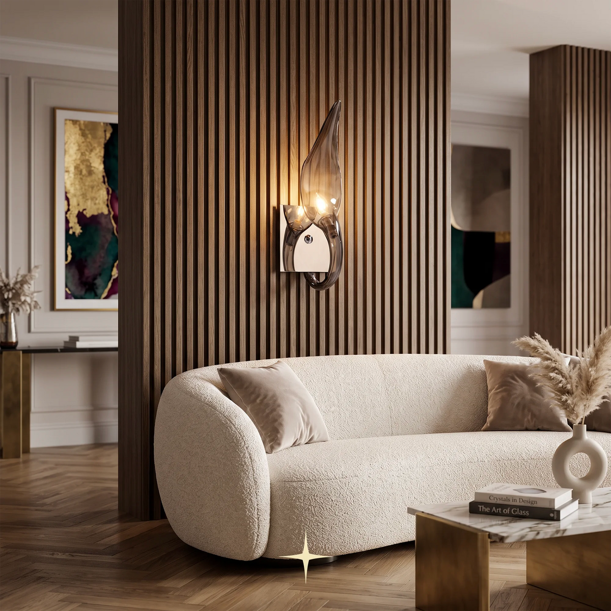 A modern wall-mounted sconce with a dark bronze abstract wing-like frame and glowing warm lights, installed on a slatted wood partition wall above a cream bouclé sofa in a styled interior.