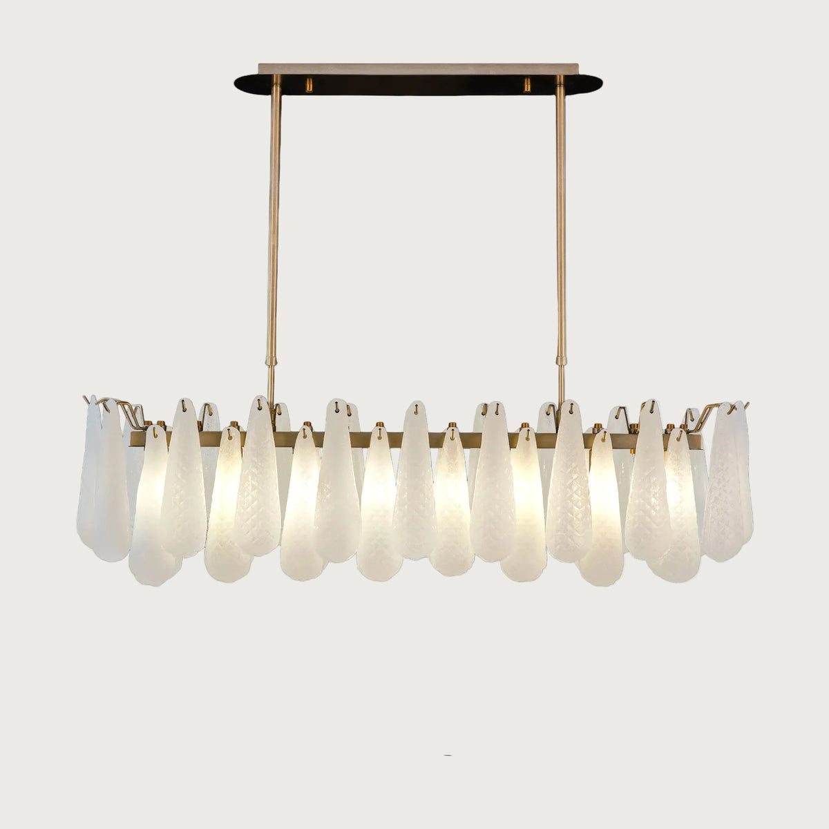 Linear Miranda horizontal brass chandelier with textured glass droplets on light grey background