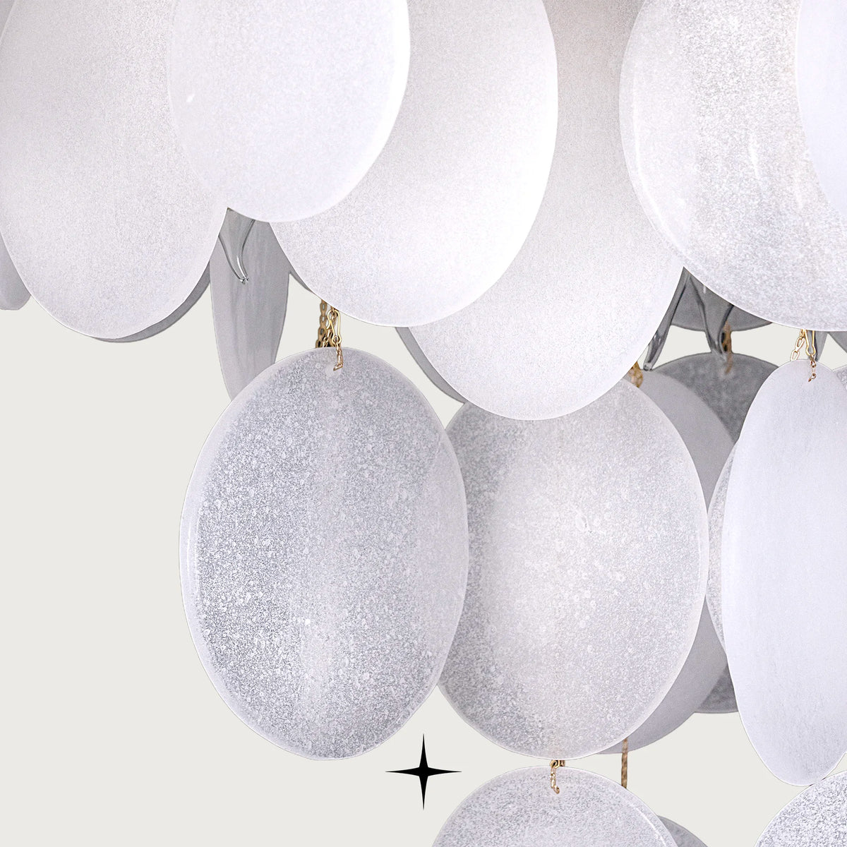 Close-up of warm illuminated frosted glass discs on Lunaria chandelier