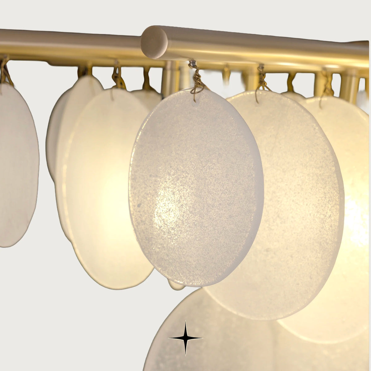 Close-up of warm illuminated frosted glass discs on Lunaria chandelier
