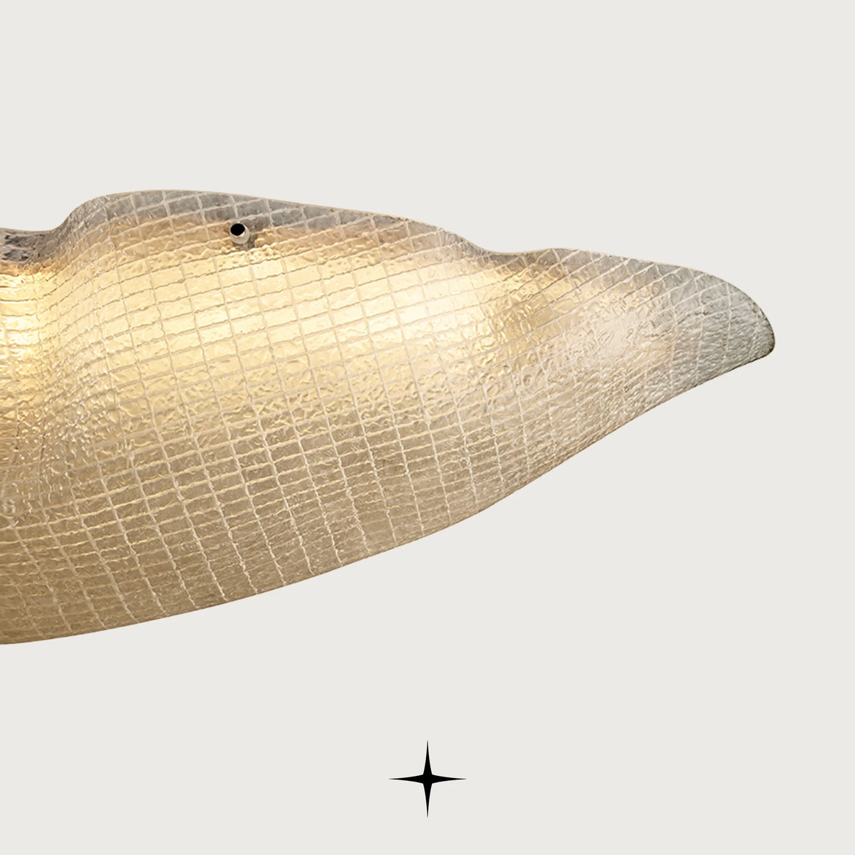Side detail of handcrafted Murano-style glass wave edge on light grey backdrop