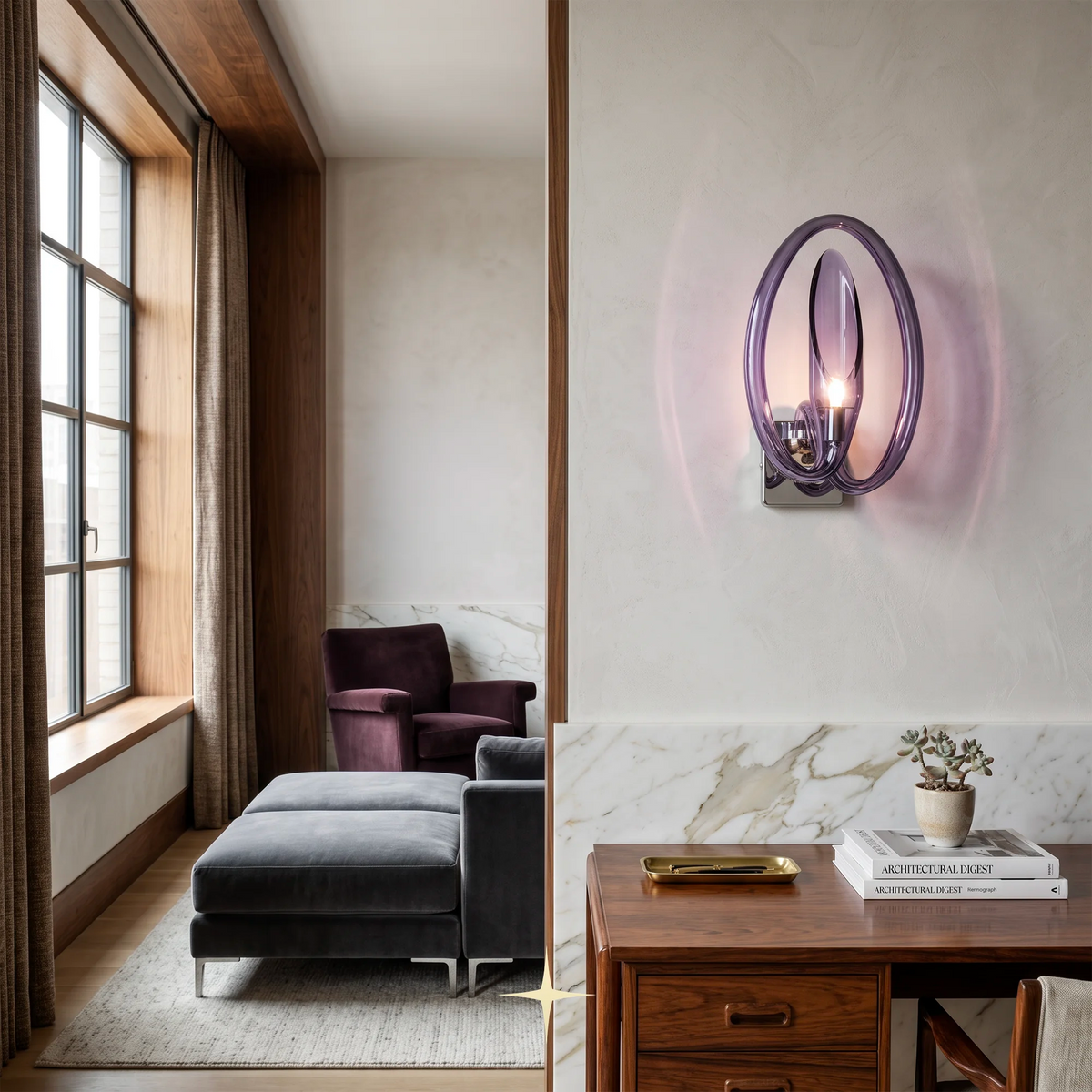 A modern wall-mounted light fixture with two overlapping oval glass shades in a purple tone, casting a pinkish glow on a white wall in a styled interior room with a sofa, chair, desk, and window.