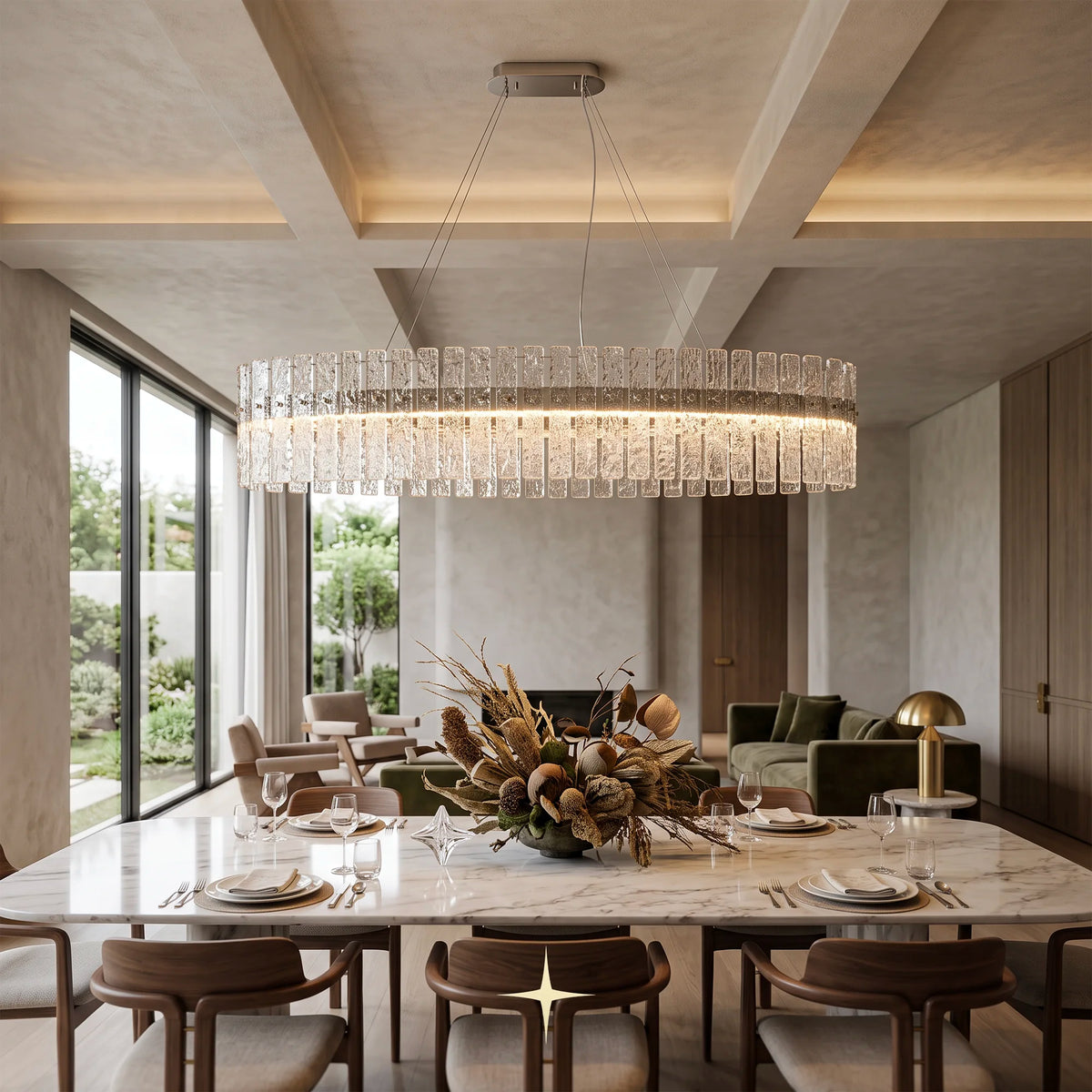 A modern oval chime chandelier with a clear glass block ring and warm LED lighting, hanging over a marble dining table in a contemporary, upscale dining room.
