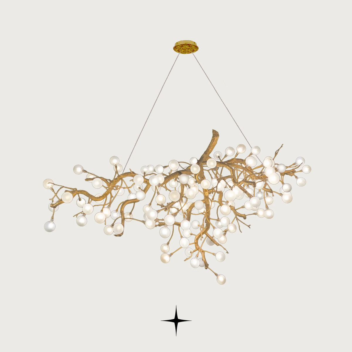 Front view of Romantica organic brass branch chandelier with white glowing bulbs on light grey backdrop