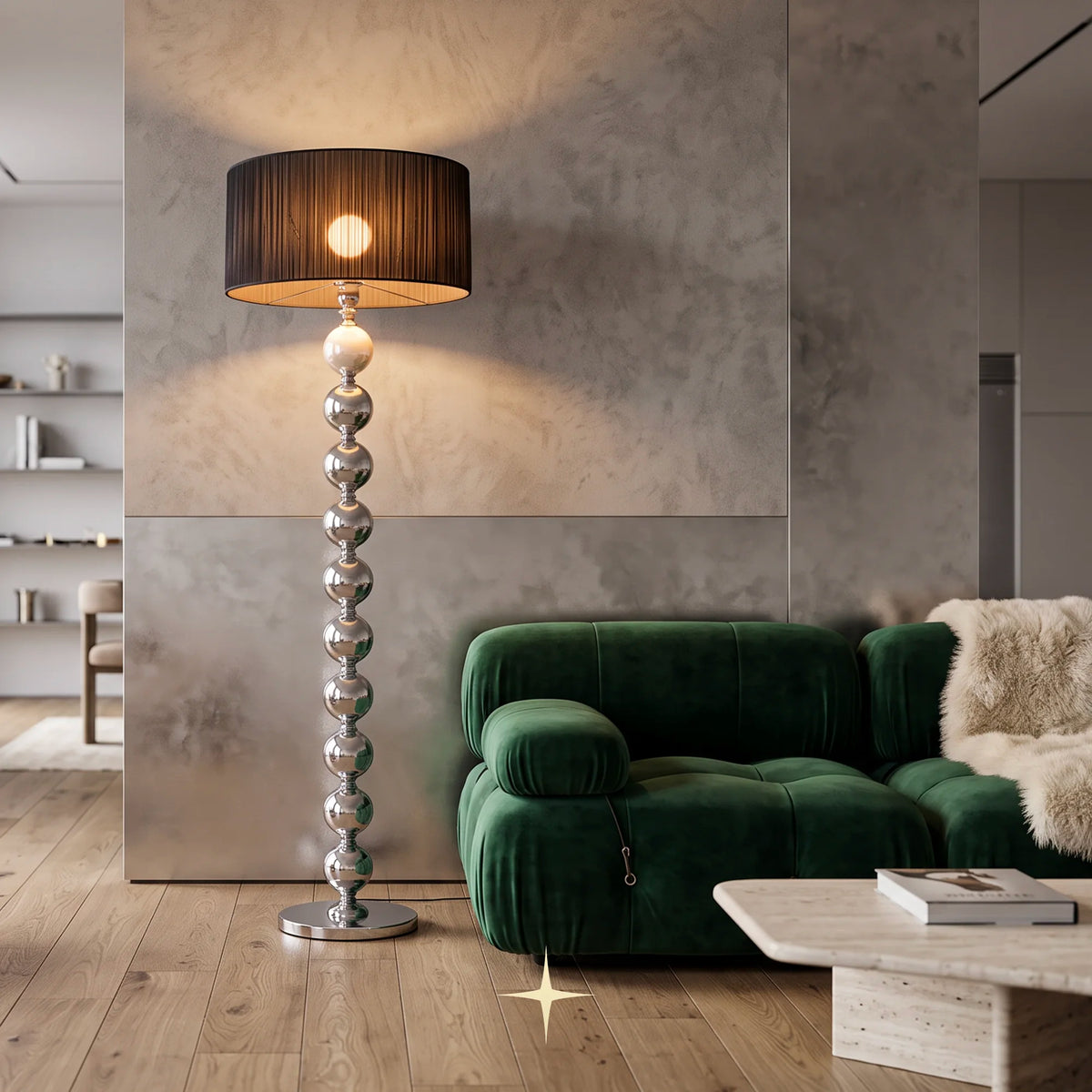 Rosalie floor lamp with stacked crystal spheres and black pleated shade beside a green velvet sofa in a contemporary living room with wood flooring and a textured gray wall.