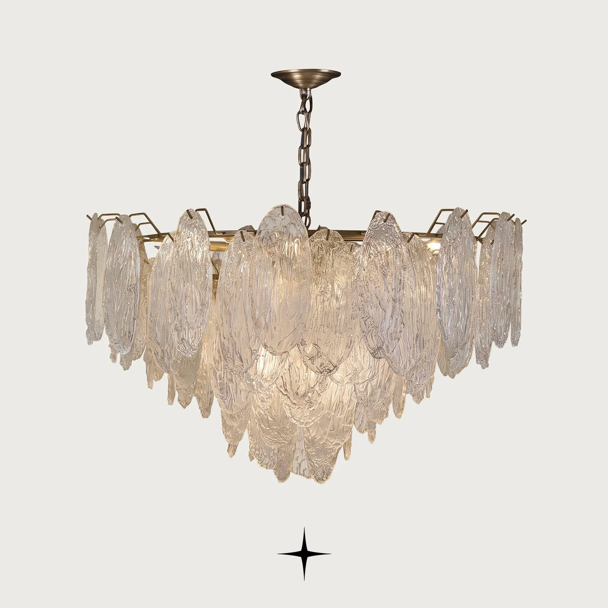 Saliva Chandelier featuring an intricate arrangement of textured glass shades resembling cascading leaves with warm brass accents