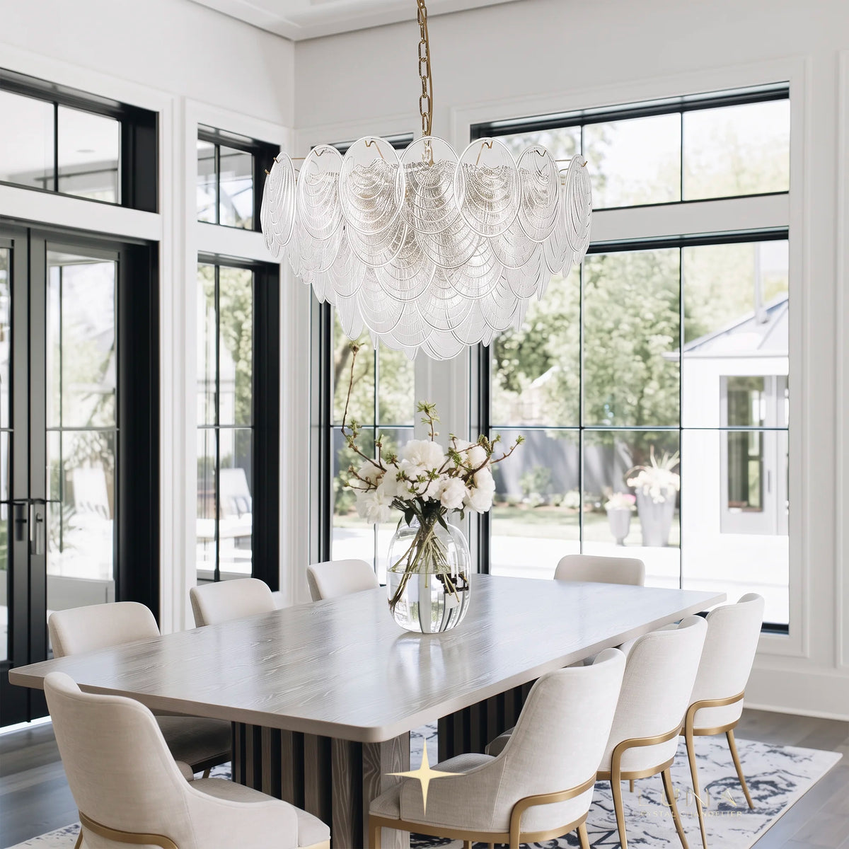 Elegant Moxie oval glass chandelier suspended over a modern luxury dining table set