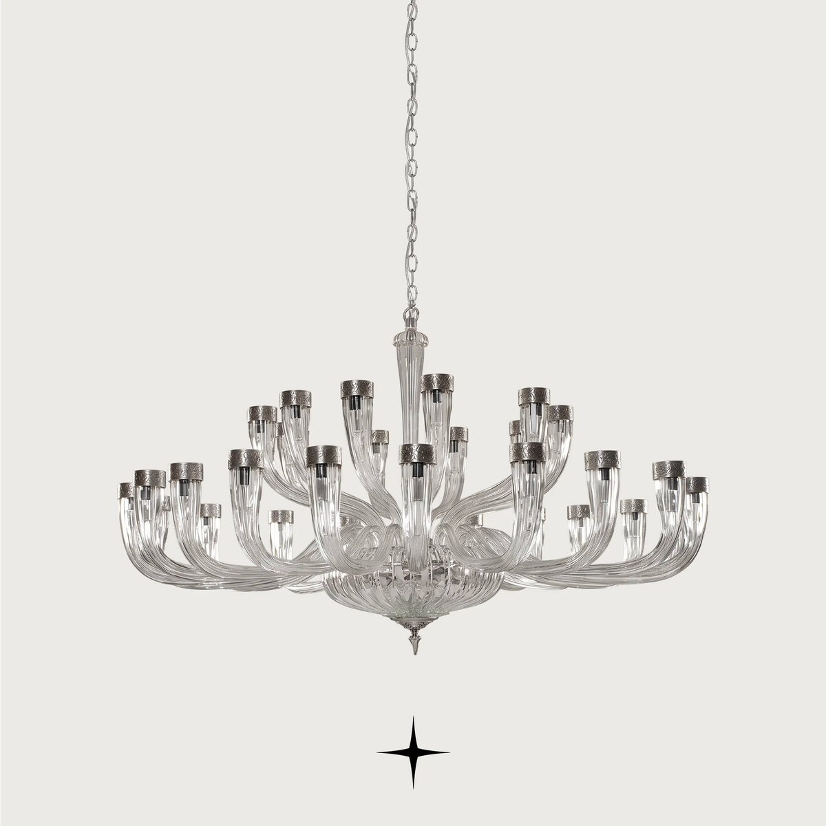 Grand Bianca Chandelier featuring chic elongated crystal arms available in three sizes and gold or silver finishes.
