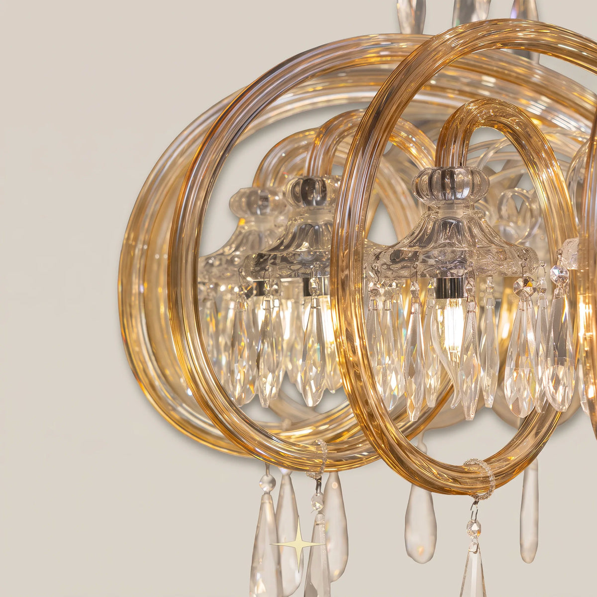 Close-up of gold ring fixture and encircling crystal elements on light grey backdrop