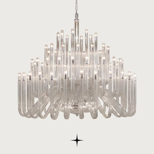 Grand Solara neo-classical crystal tube chandelier illuminated on a light grey background