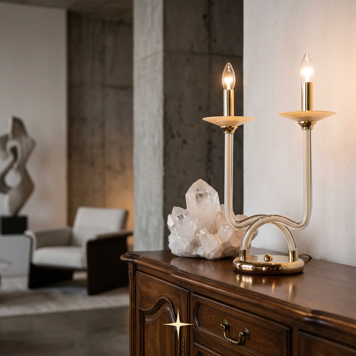 Harmony luxury Bohemian crystal table light with dual candle arms table lamp with curved brass-toned metal arms and cream-colored shades, shown lit on a dark wood console table in a stylishly decorated room.