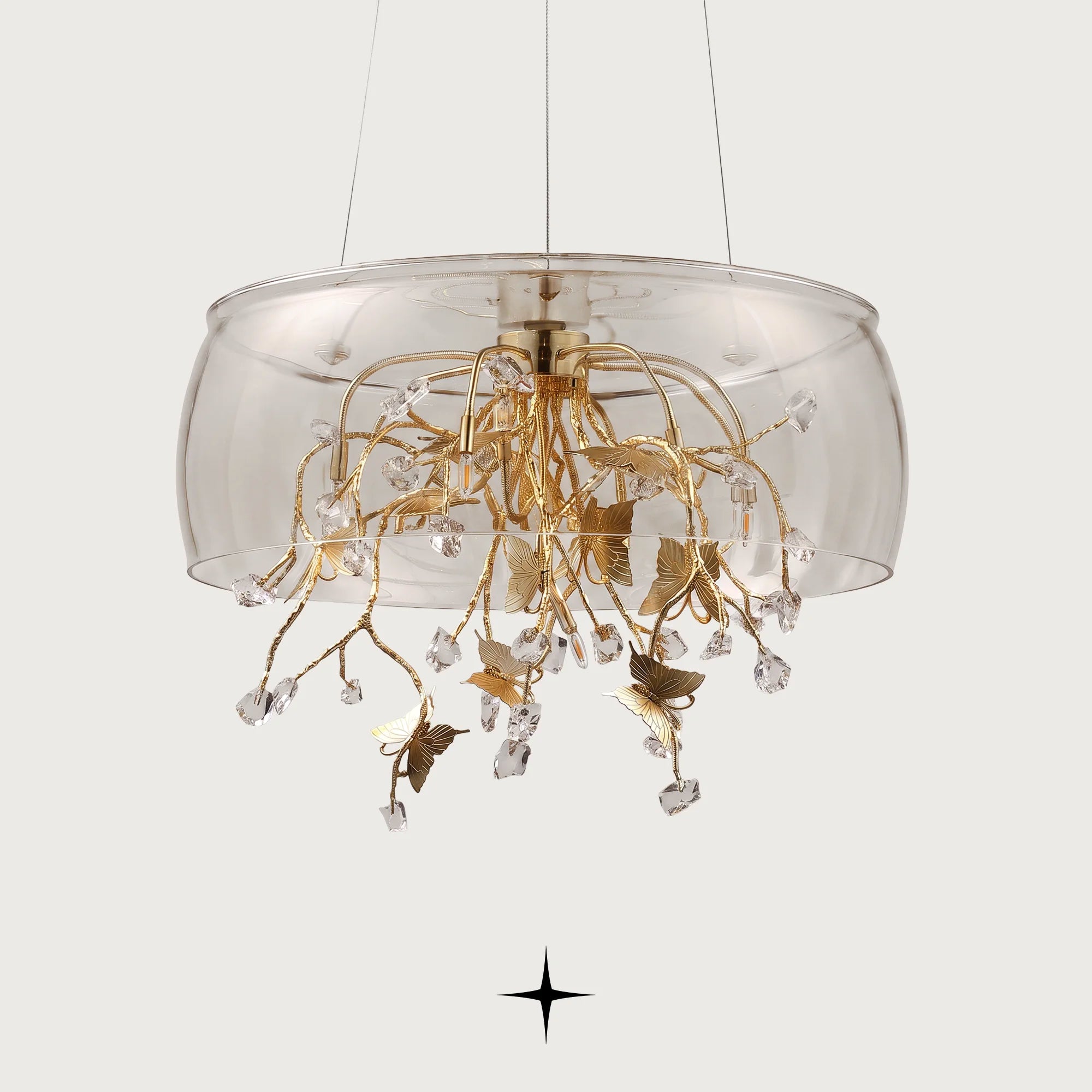 Close-up detail of golden butterfly accent resting on a crystal block within Imagina chandelier