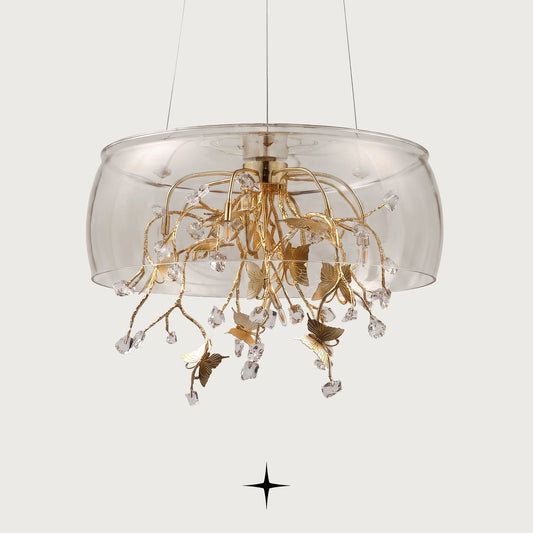 Close-up detail of golden butterfly accent resting on a crystal block within Imagina chandelier