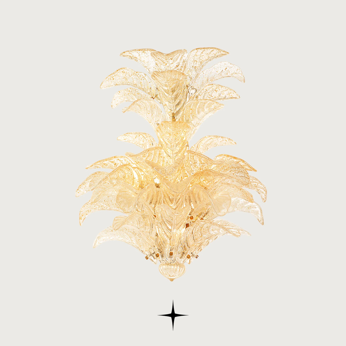 Lavish Madam gold-tinted glass leaf wall light illuminated on light grey backdrop