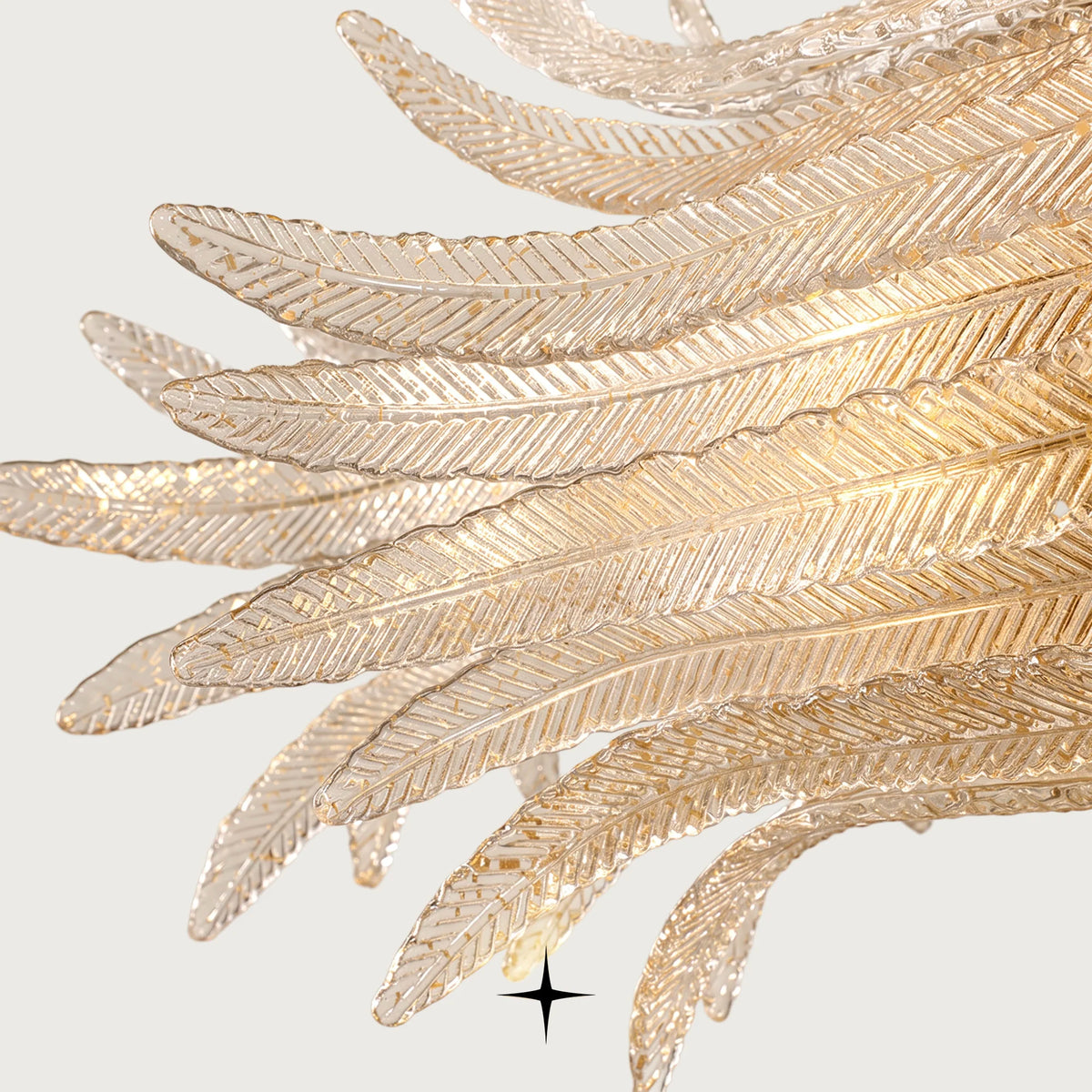 Close-up detail of handcrafted textured glass feather diffusers on Linear Golden Falls chandelier
