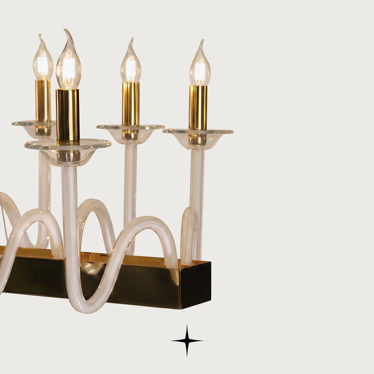 Close-up detail of fluid curved glass arms and candle sockets on Linear Harmony fixture