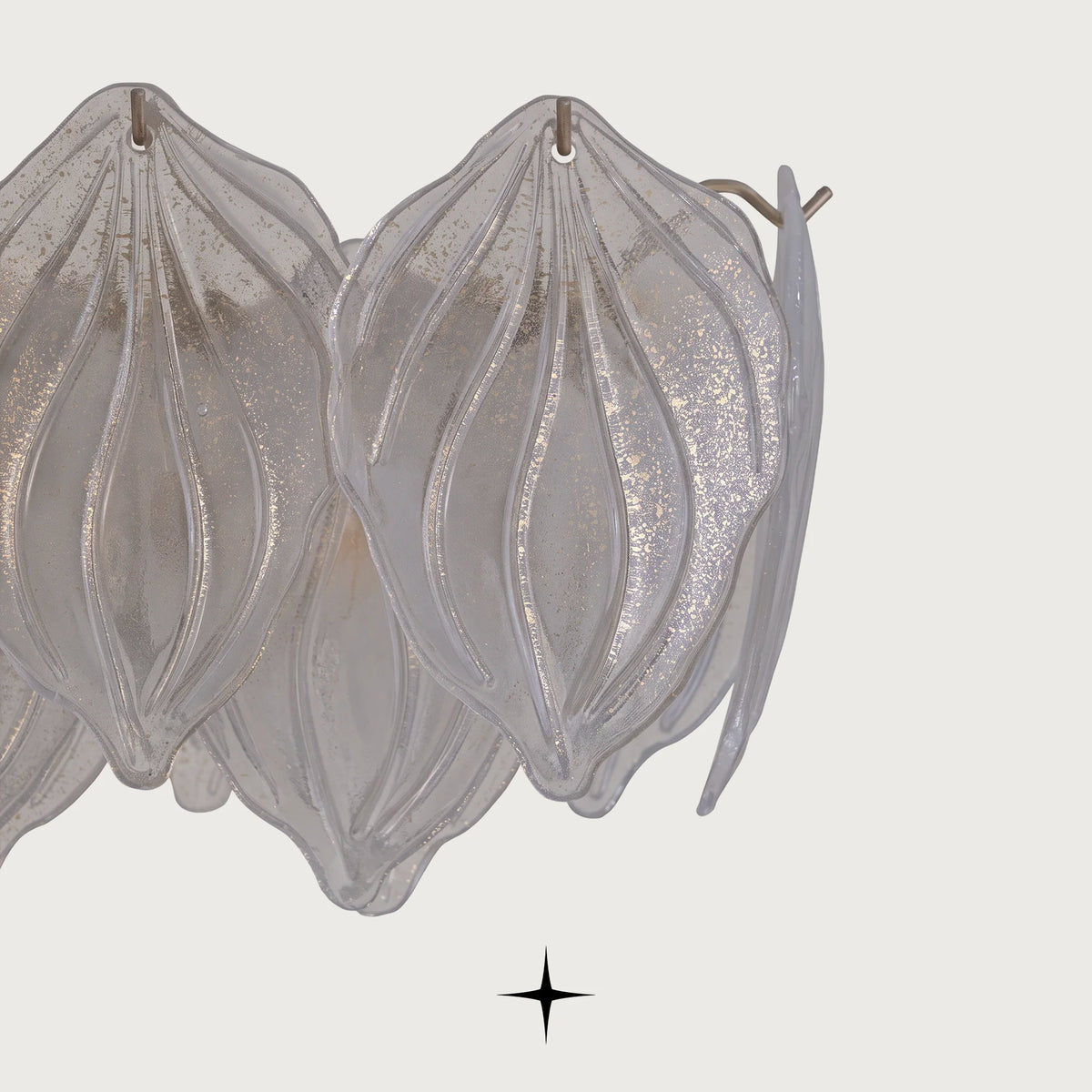 Close up view of delicate textured glass leaf diffusers on Linear Mellow chandelier