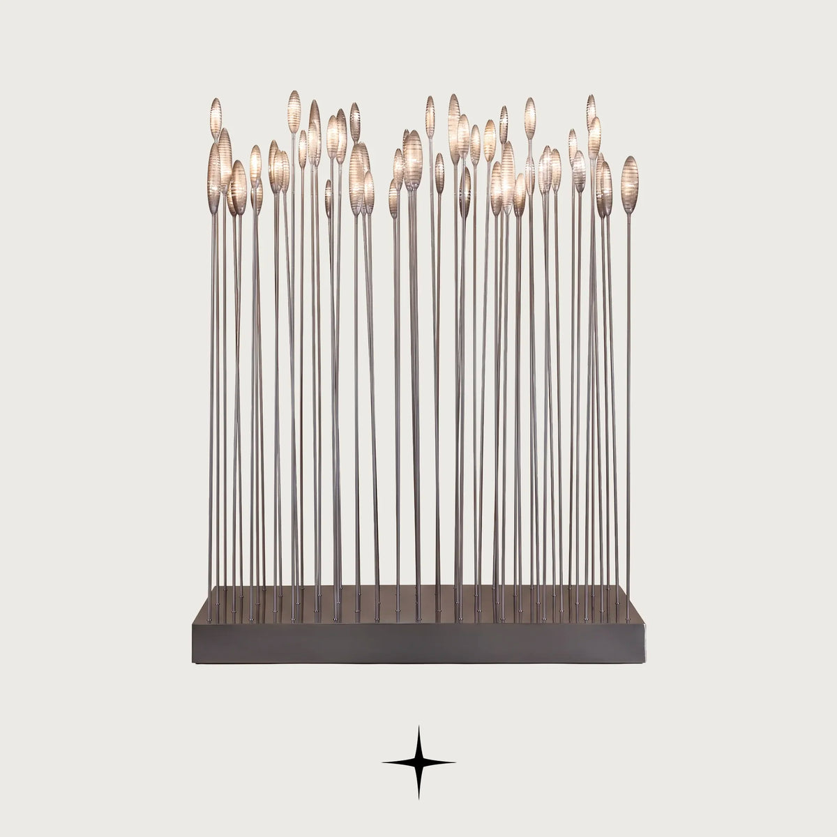Reeda floor lamp with slender metal rods and illuminated glass flower tops on a light grey background