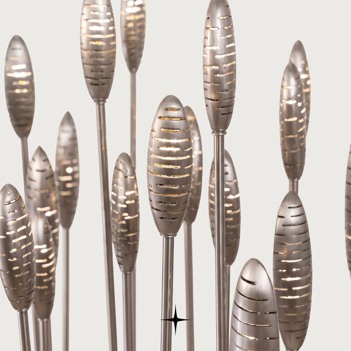 Close-up of intricately designed illuminated glass flower tops on Reeda floor lamp with light grey backdrop