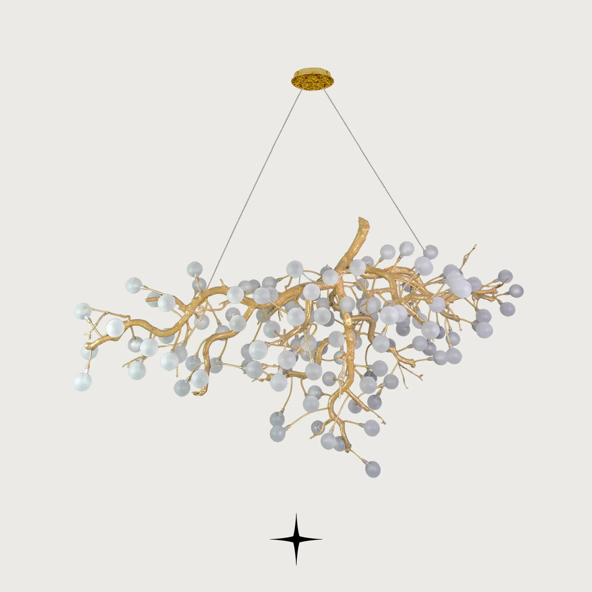 Front view of Romantica organic brass branch chandelier with white glowing bulbs on light grey backdrop