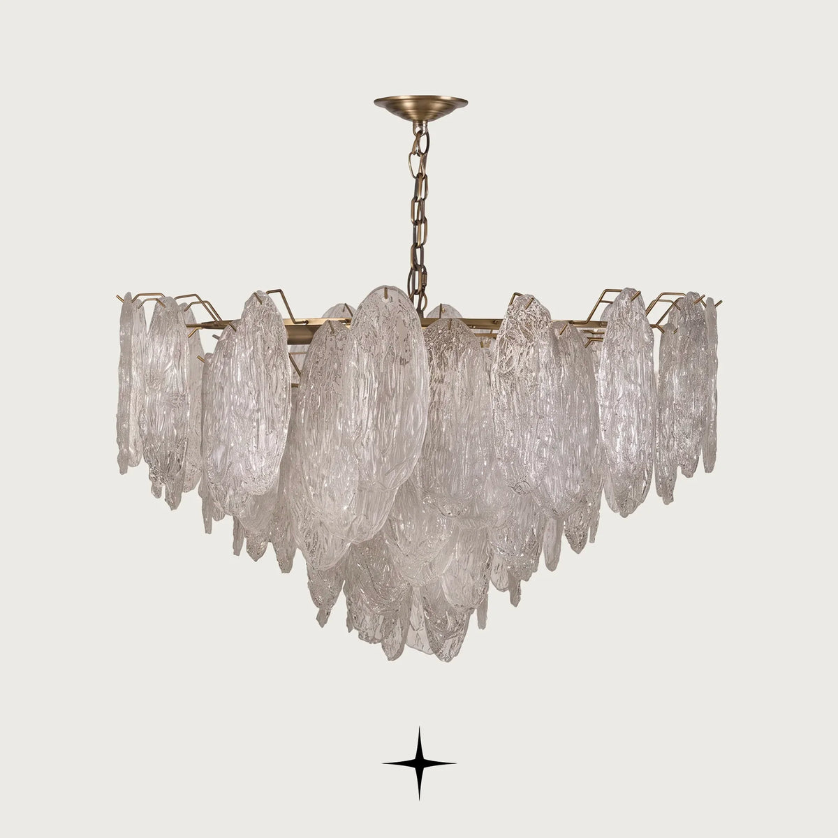 Saliva Chandelier featuring an intricate arrangement of textured glass shades resembling cascading leaves with warm brass accents
