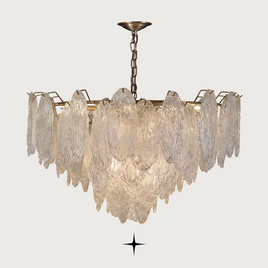 Saliva cascading textured glass leaf chandelier with brass frame on light grey background