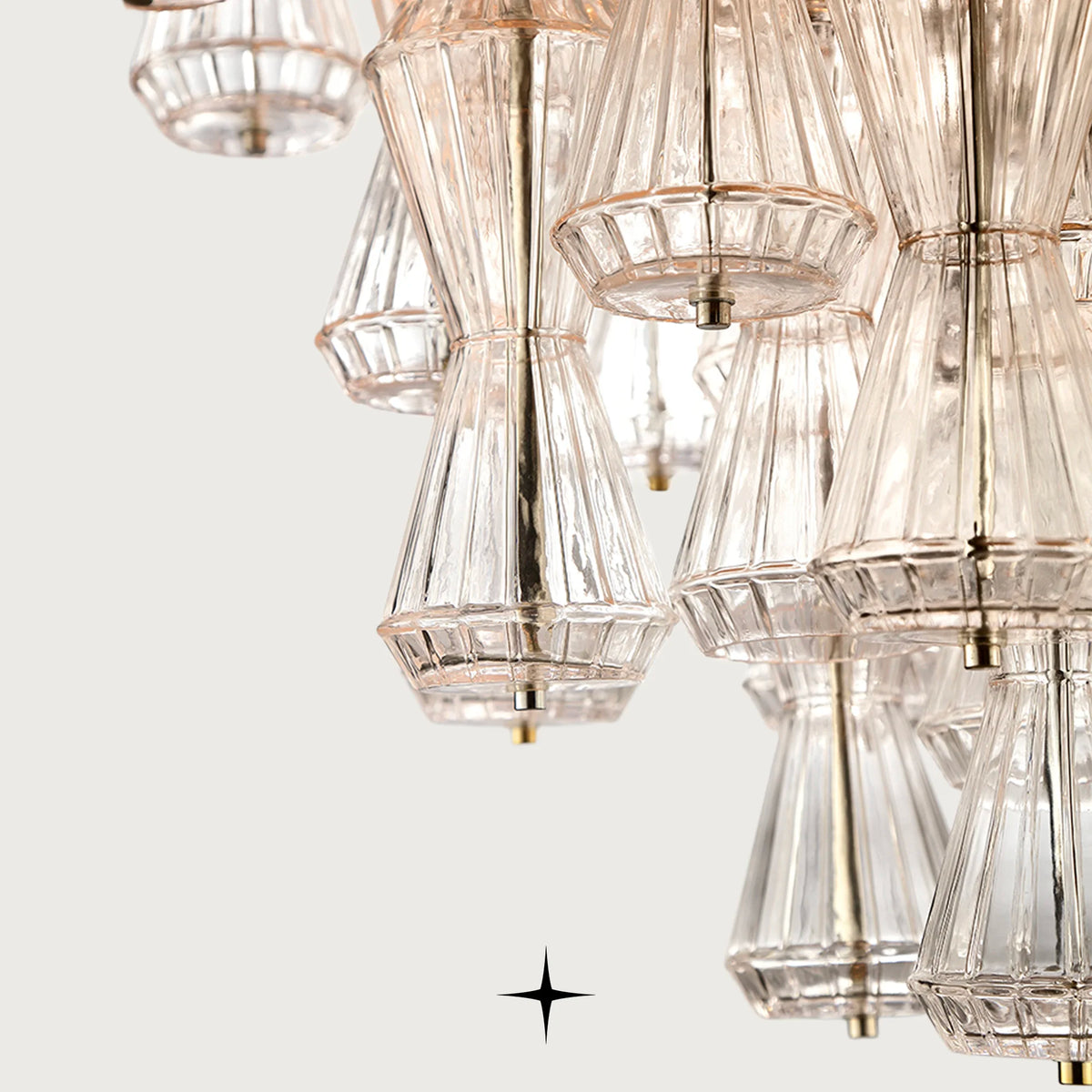 Hourglass shaped Rigadin glass suspension chandelier light on dark background
