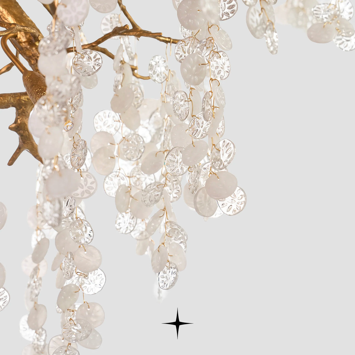 Detailed view of cascading crystal droplet strands on light grey backdrop