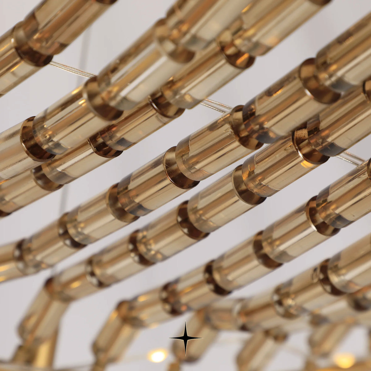 Close-up detail of golden metal structure and suspended crystals on Vortex chandelier