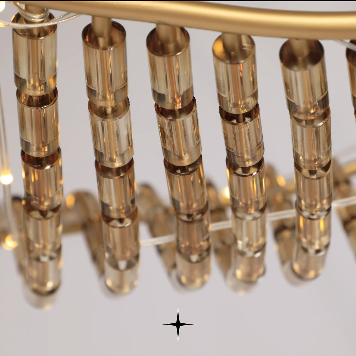 Close-up detail of golden metal structure and suspended crystals on Vortex chandelier